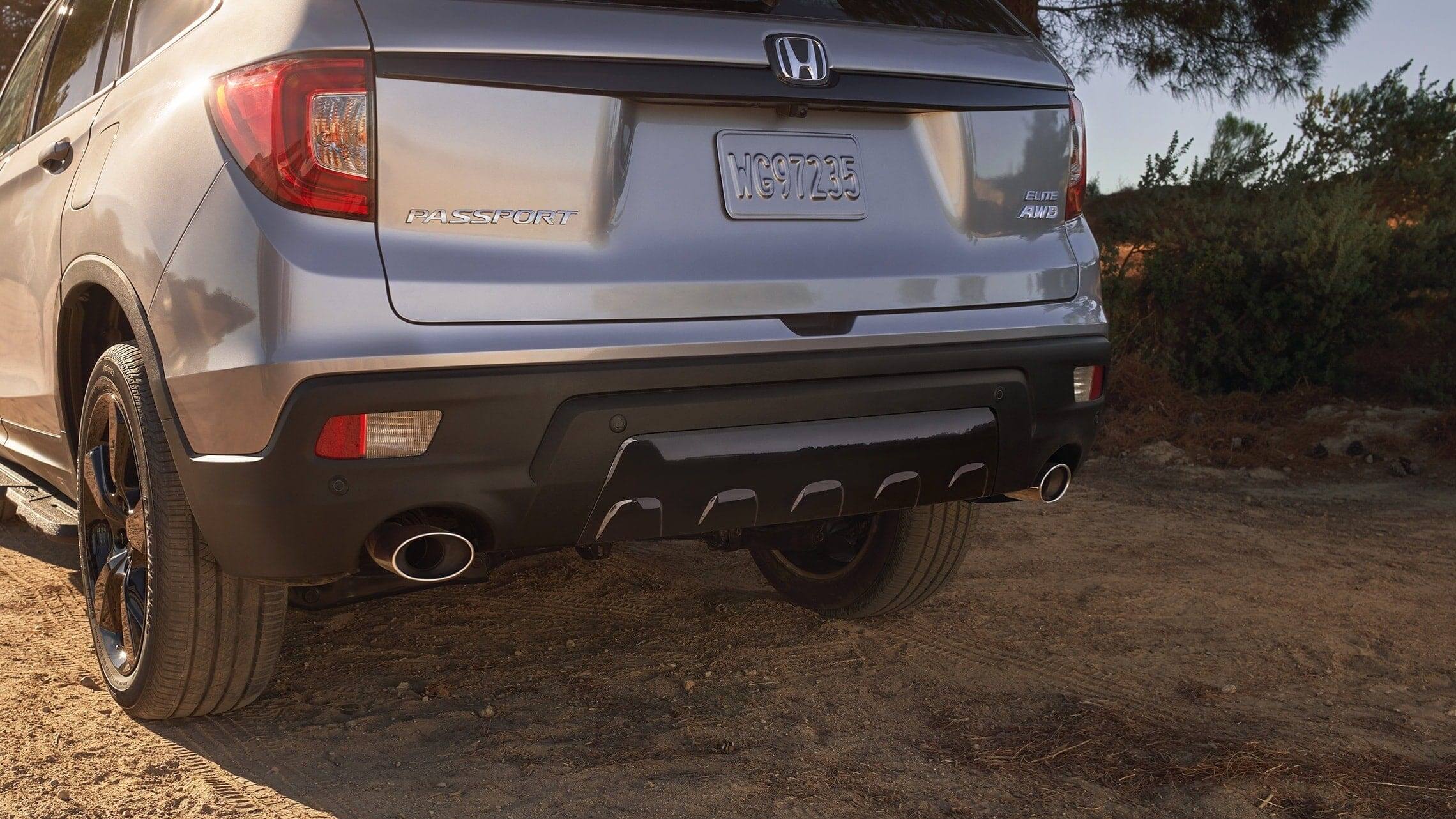 Dual exhaust finishers with parking sensors on the 2019 Honda Passport Elite in Lunar Silver Metallic.