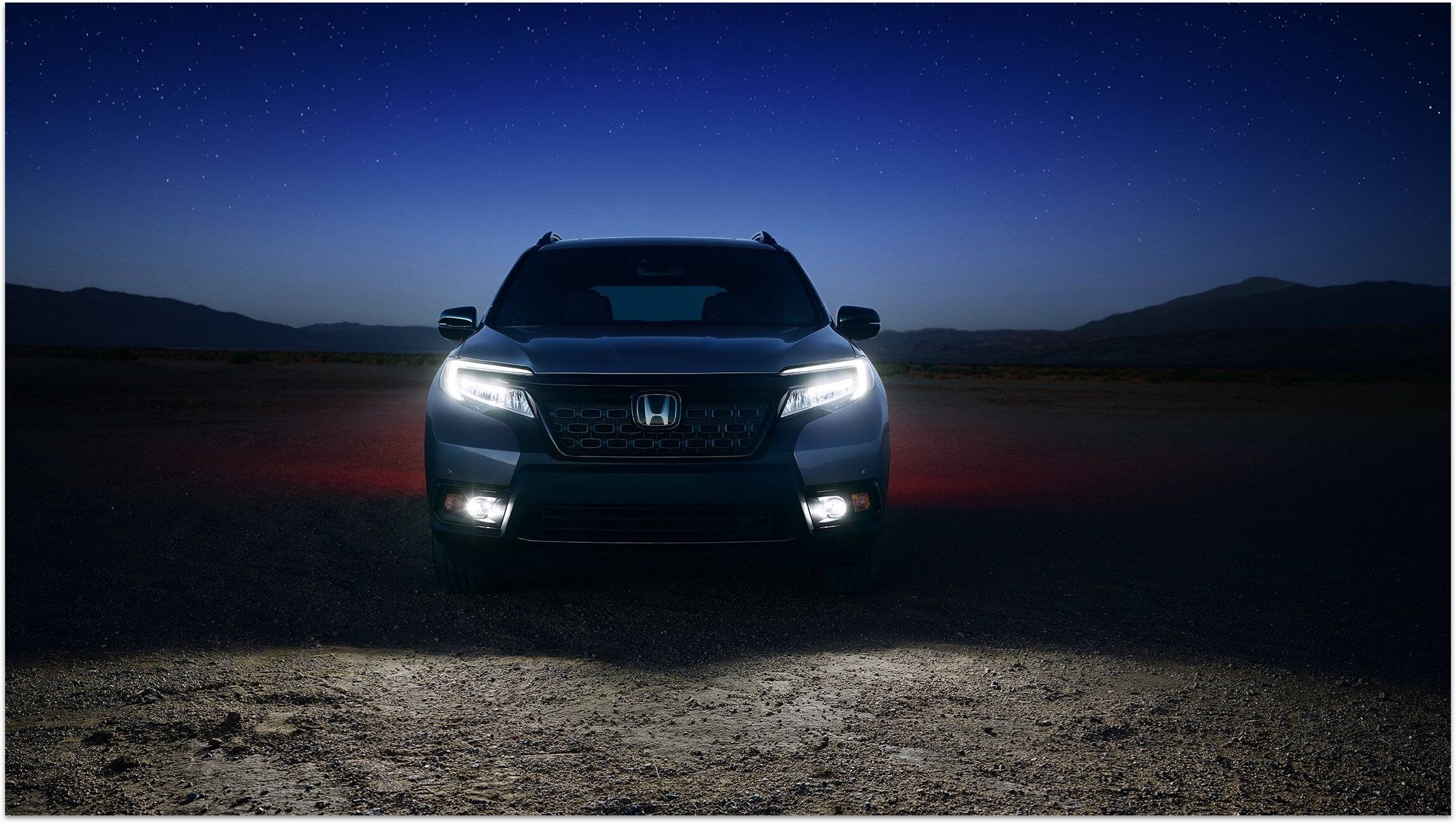 Direct front view of 2019 Honda Passport Elite in Modern Steel Metallic with LED low-beam headlights and fog lights on.
